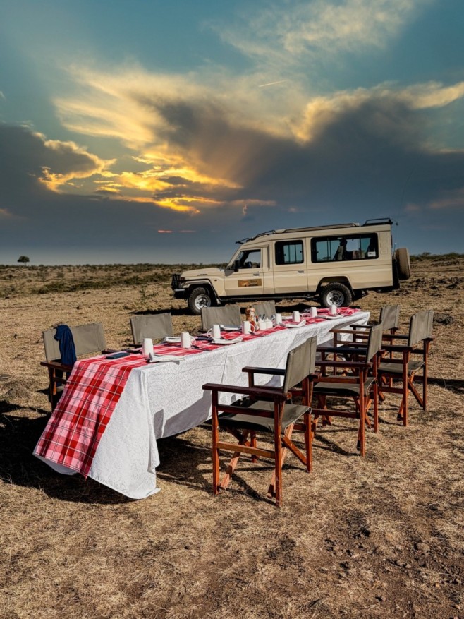 set up of mara dining Guests enjoying a sunset dinner in the Maasai Mara, experiencing a memorable African safari with The Out Of Africa Experience.